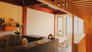 Una cocina moderna con barra, vigas de madera y vistas al exterior.