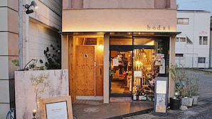 Una fachada de madera con el nombre 'bodai' iluminado sobre la entrada.