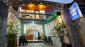 A hotel entrance with a reception desk, a staircase, and a sign indicating 'VIP House'. - Vip House Hoi An (Da Nang)