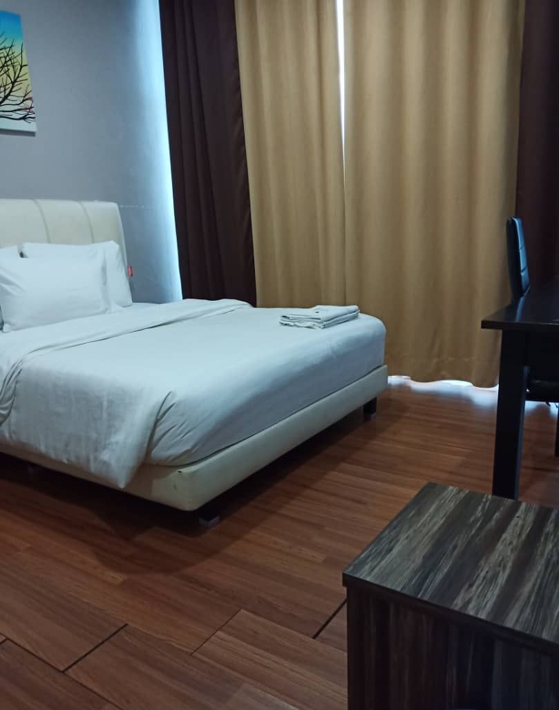 A hotel room with a bed, a desk, and a chair.