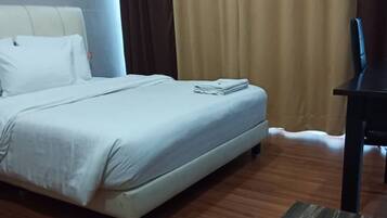A hotel room with a bed, a desk, and a chair.