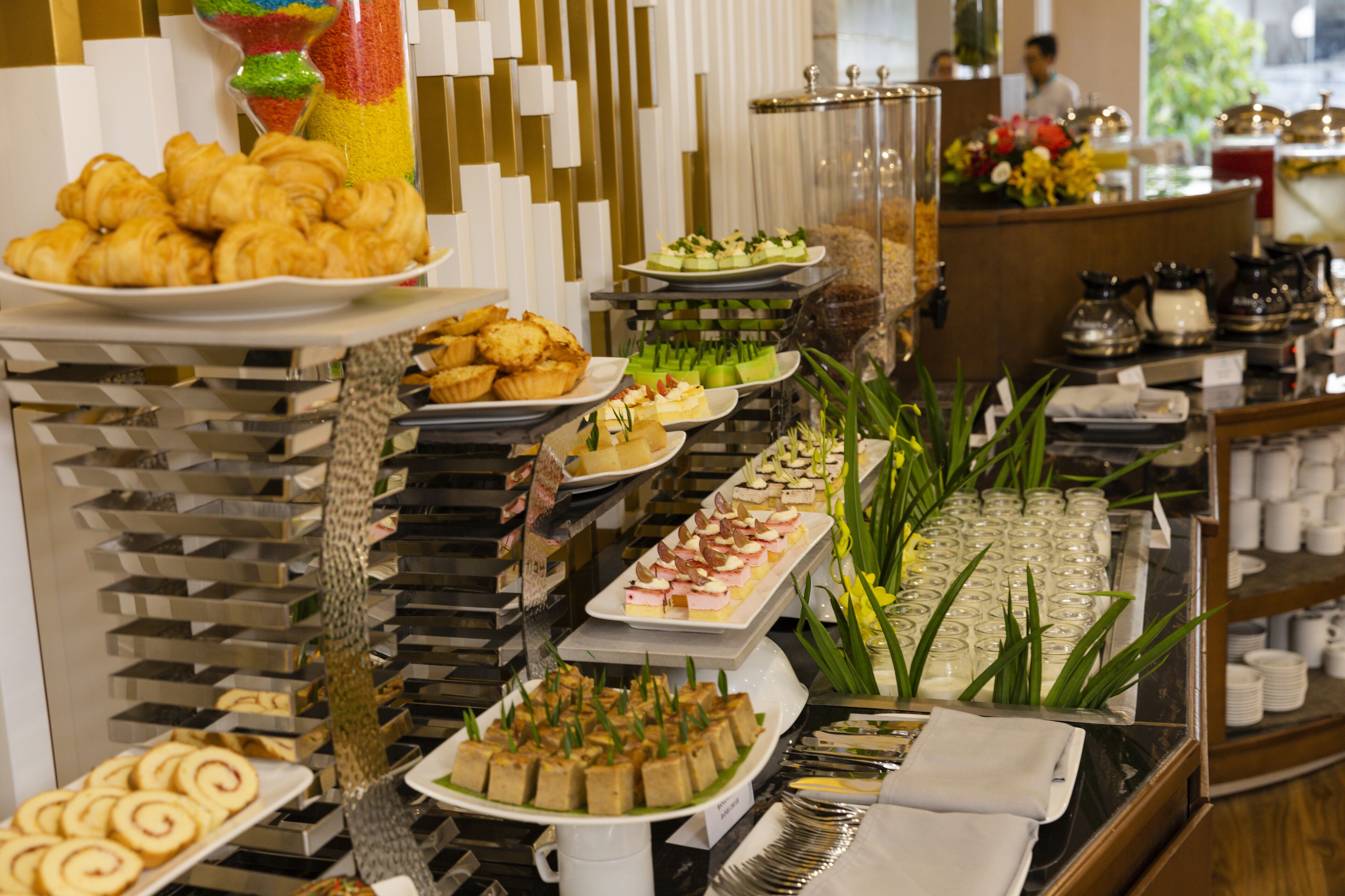 Un bufé con diversas opciones de comida, como pasteles, ensaladas y postres.