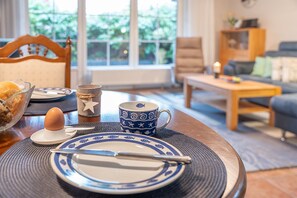 Une table à manger avec une assiette, une tasse et un bol de pain.
