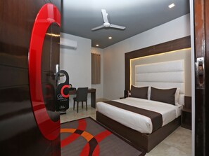 A modern hotel room with a large bed, a desk, and a chair. - Hotel Sunrise Moon (New Delhi)