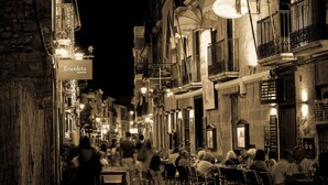 A narrow street lined with buildings, some with outdoor seating areas and tables. - 0676 Villa Molins Tauro (Denia)