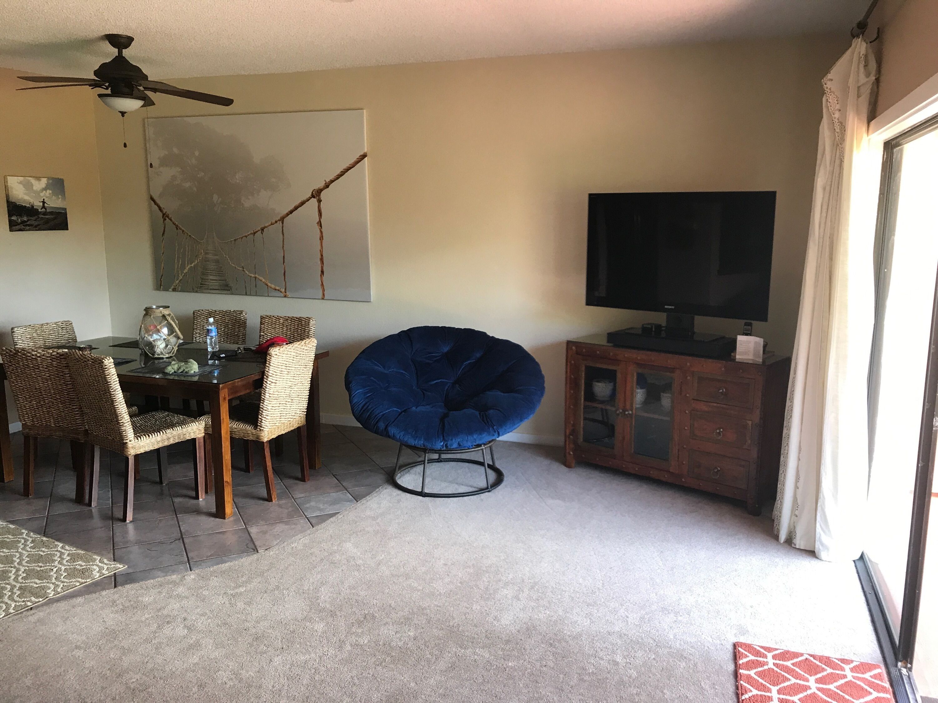 Un comedor con una mesa, sillas y un sillón informal azul.