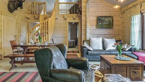 A log cabin interior with a dining area, a sofa, a coffee table, and a staircase. - Ruuhikari by Interhome (Ulvila)