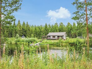 A house by a lake with a dock and a small boat. - Ruuhikari by Interhome (Ulvila)
