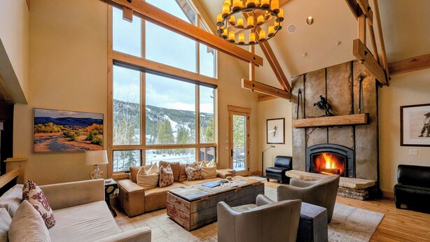 A spacious living room with large windows, a fireplace, and a cozy seating area. - Custom Keystone Retreat – Summer Events/Hot Tub (Keystone)