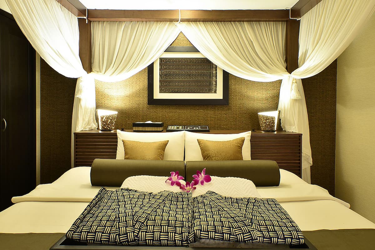 A well-lit bedroom with a bed, nightstands, and a canopy.