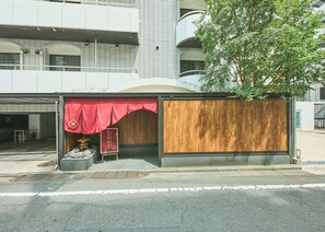 A building with a covered entrance, a wooden door, and a red awning. - Ikebukuro Retro Hotel (Tokyo)