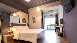 A modern bedroom with a large bed, bedside table, lamp, and potted plants. - Mango 10 House (Bangkok)