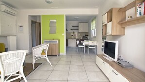 Una cucina moderna con zona pranzo, televisore e libreria.