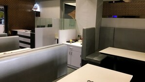 Un interior de restaurante moderno con asientos tipo cabina, una barra y una zona de bar.