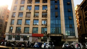 Un hotel de varios pisos con fachada moderna, que combina vidrio y concreto.
