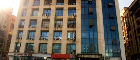 Un hotel de varios pisos con fachada moderna, que combina vidrio y concreto.