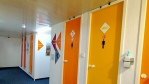 A hallway with doors marked for different floors and amenities, including a WC. - Hotel Thania (Frontignan)