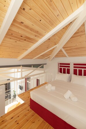 A bedroom with a wooden ceiling, a bed with white bedding, and a view of the outdoors. - Ether Loft Suites (Athens)