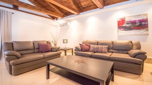A modern living room with two leather sofas, a coffee table, and a small side table. - Villa Lucia (Marcana)