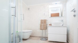 A modern bathroom with a glass shower enclosure, a toilet, and a sink with a mirror above it. - Villa Duda (Vodnjan)