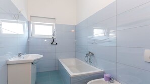 Ein modernes Badezimmer mit einer Badewanne, einem Waschbecken und einer Toilette.