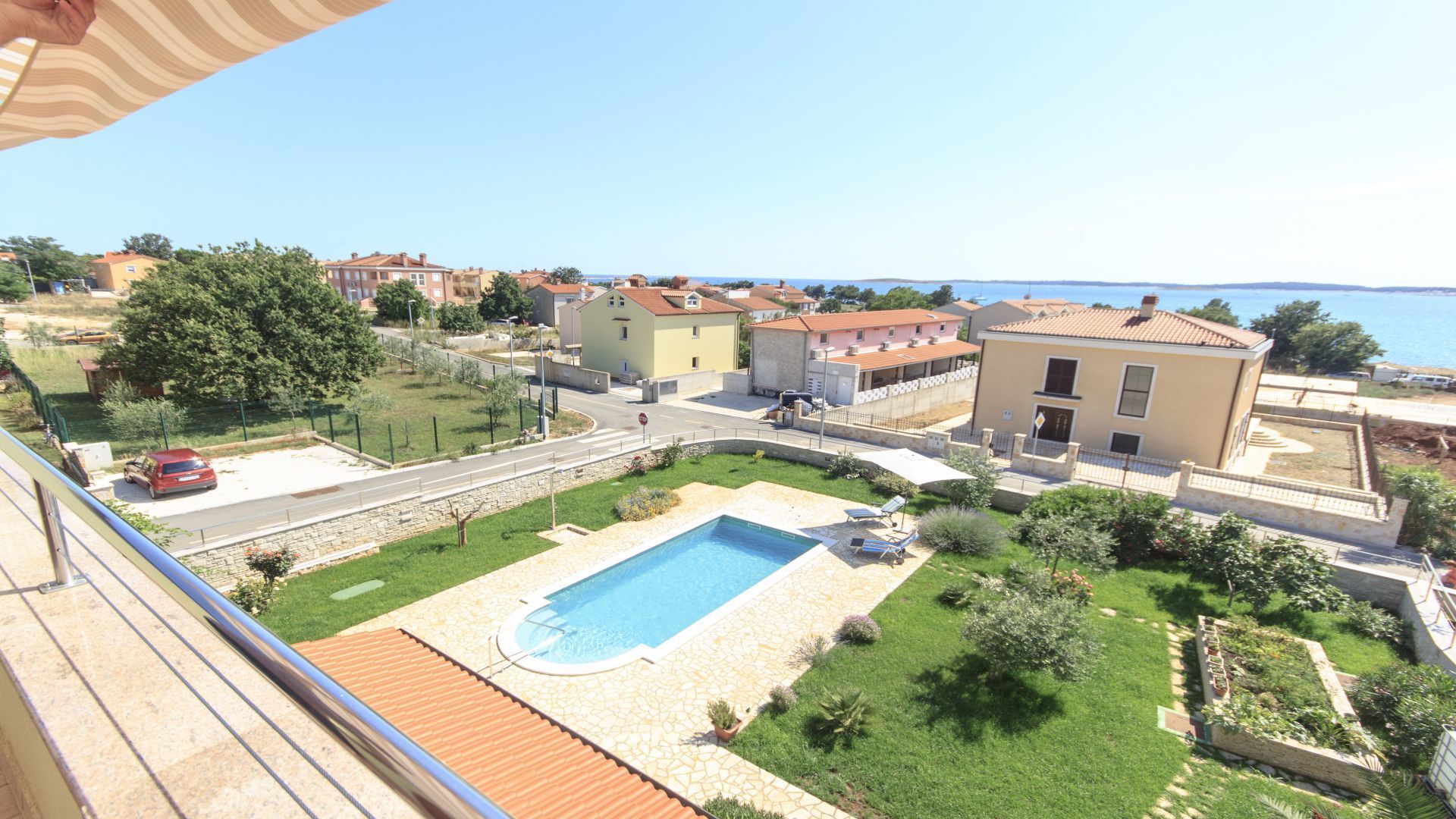 Un quartier résidentiel doté d’une piscine, de maisons et offrant une vue dégagée sur la mer.