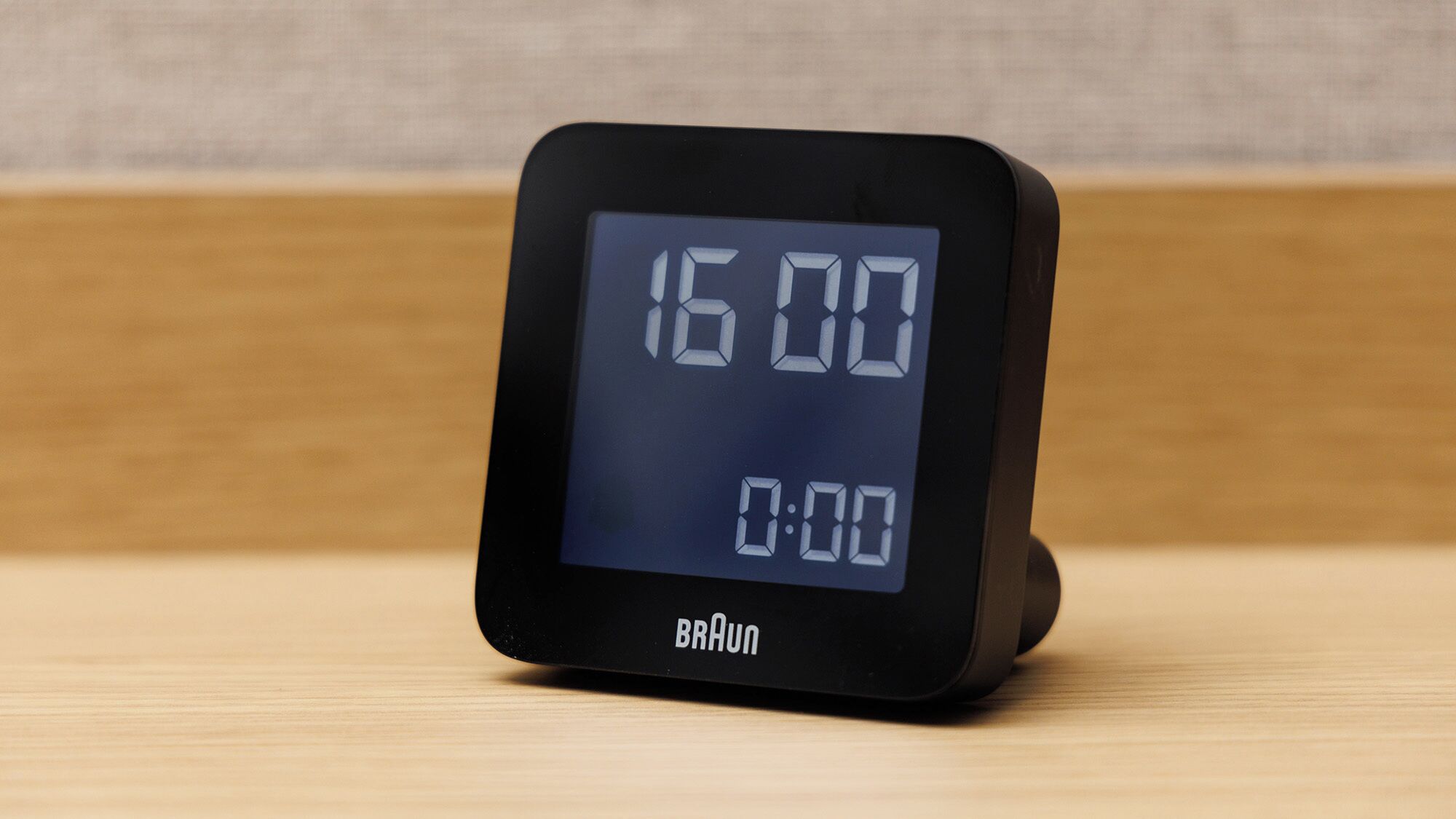 A digital clock displaying 16:00 and 0:00, with the brand name 'BRAUN' visible on the base.