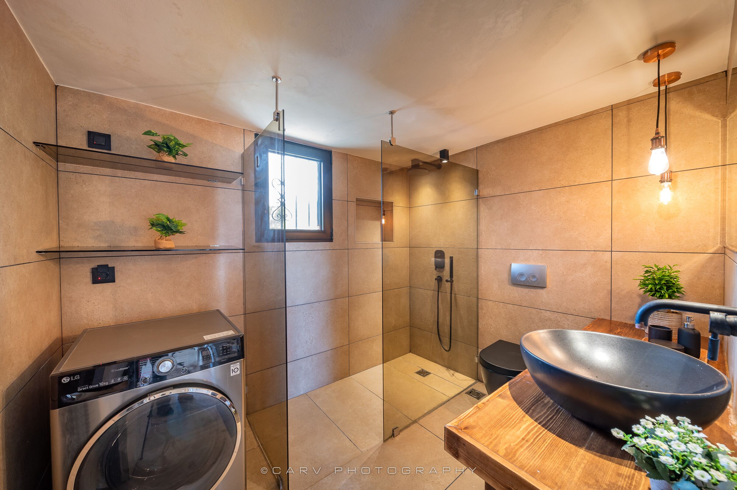 Ein modernes Badezimmer mit integriertem Waschbecken, einer Glasdusche und einem Holzbadezimmer-Möbel mit großem Waschbecken.