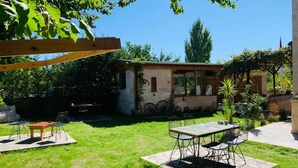 A small house with a patio area, a table with chairs, and a garden. - Kapadokya Konak (Nevsehir)