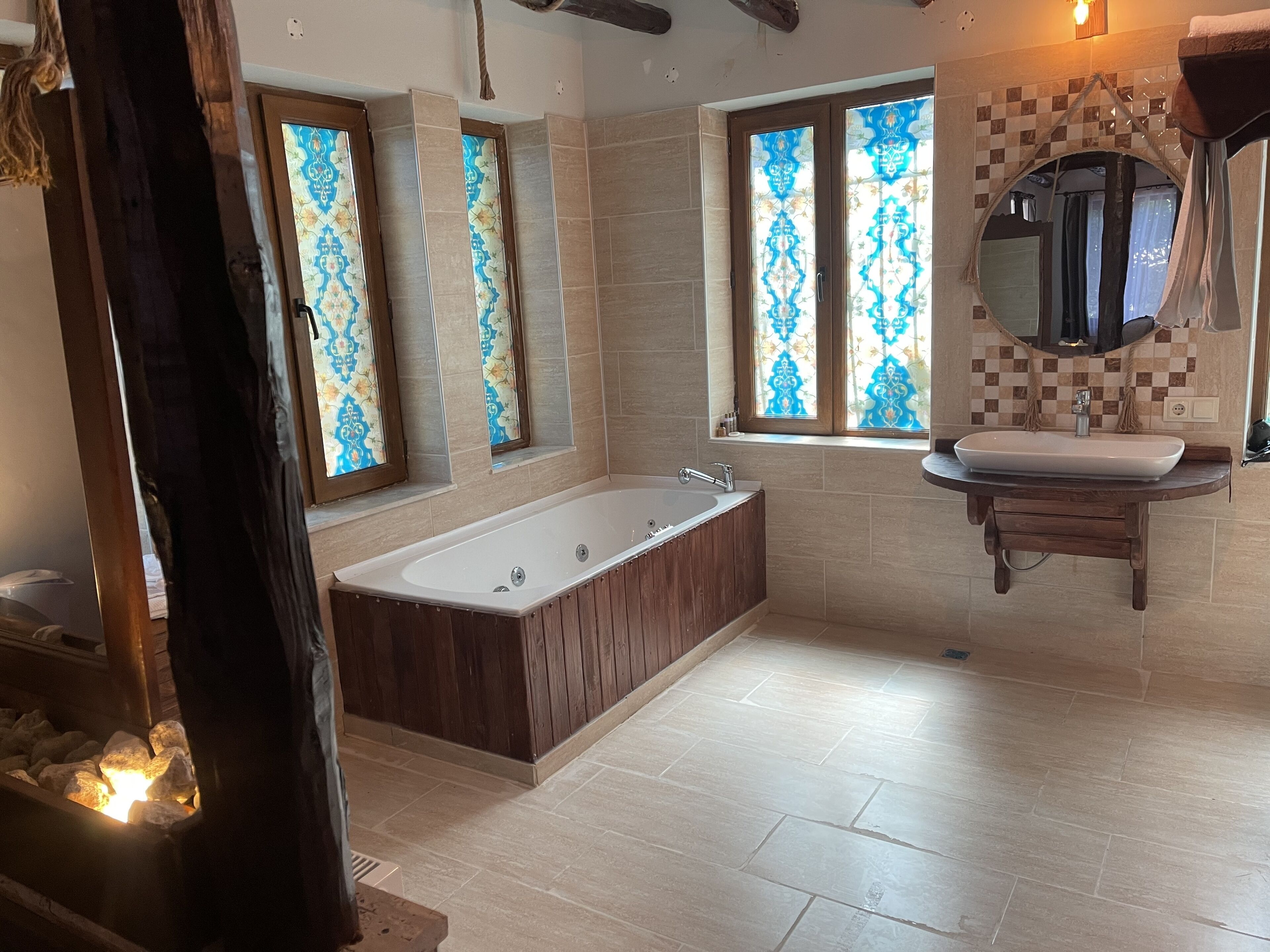 A modern bathroom with a freestanding bathtub, a vanity with a mirror, and decorative tiles.