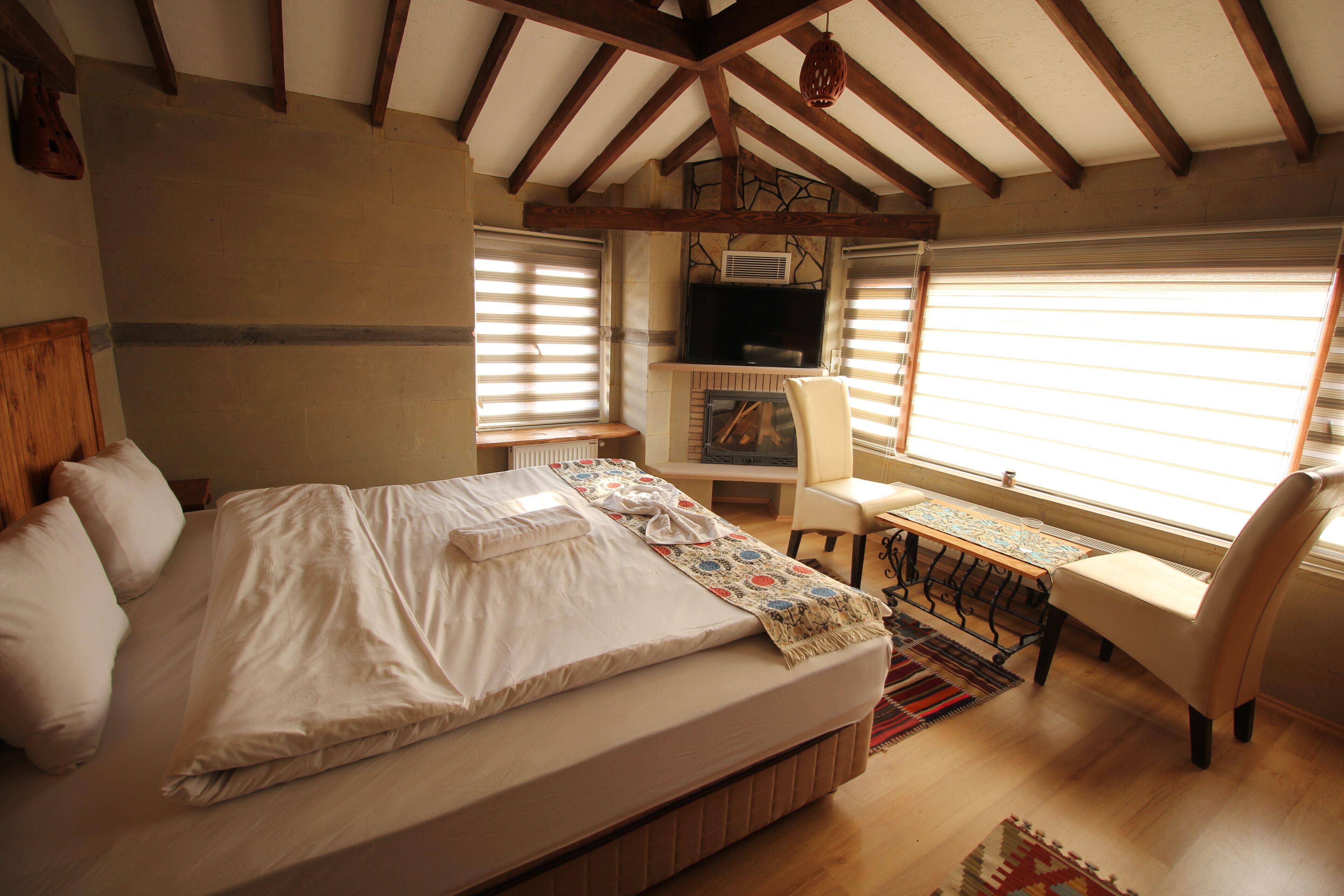 Un dormitorio con cama, escritorio, silla y televisor.