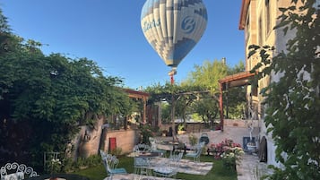 A courtyard with a hot air balloon, outdoor seating, and a pergola.