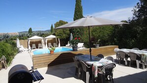 An outdoor pool area with lounge chairs, a barbecue grill, and a table with umbrellas. - Charming cottage with pool, fountains, mill, park and plane trees (Apt)
