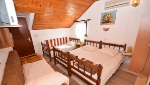 Une chambre avec deux lits, un plafond en bois, un climatiseur, un tableau et une porte.