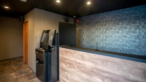 Un espace d’accueil moderne avec un comptoir de réception en bois, une poubelle et un mur à texture.