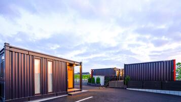 Un bâtiment moderne doté d’une grande entrée et d’un espace extérieur abrité.