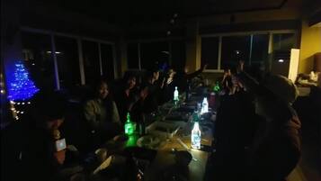 A dimly lit room with a group of people gathered around a table.