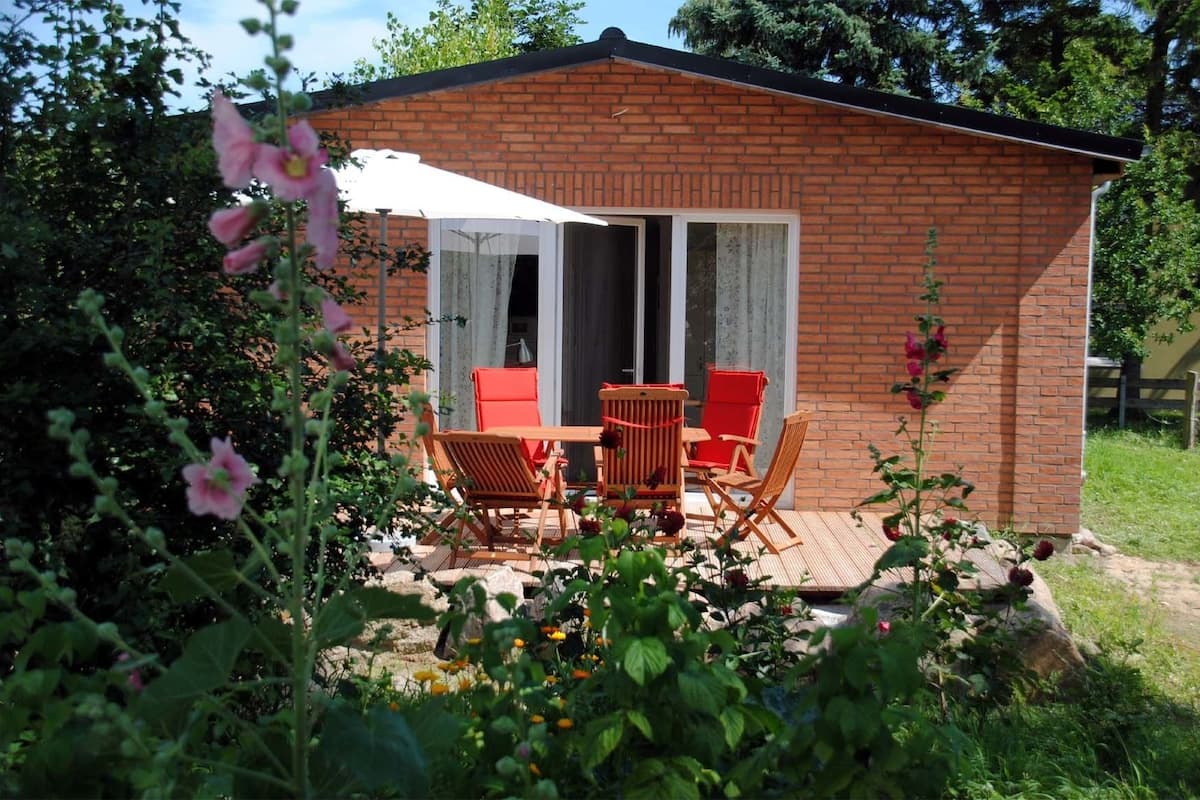 Un petit bâtiment en briques doté d’un patio comprenant une table et deux chaises.