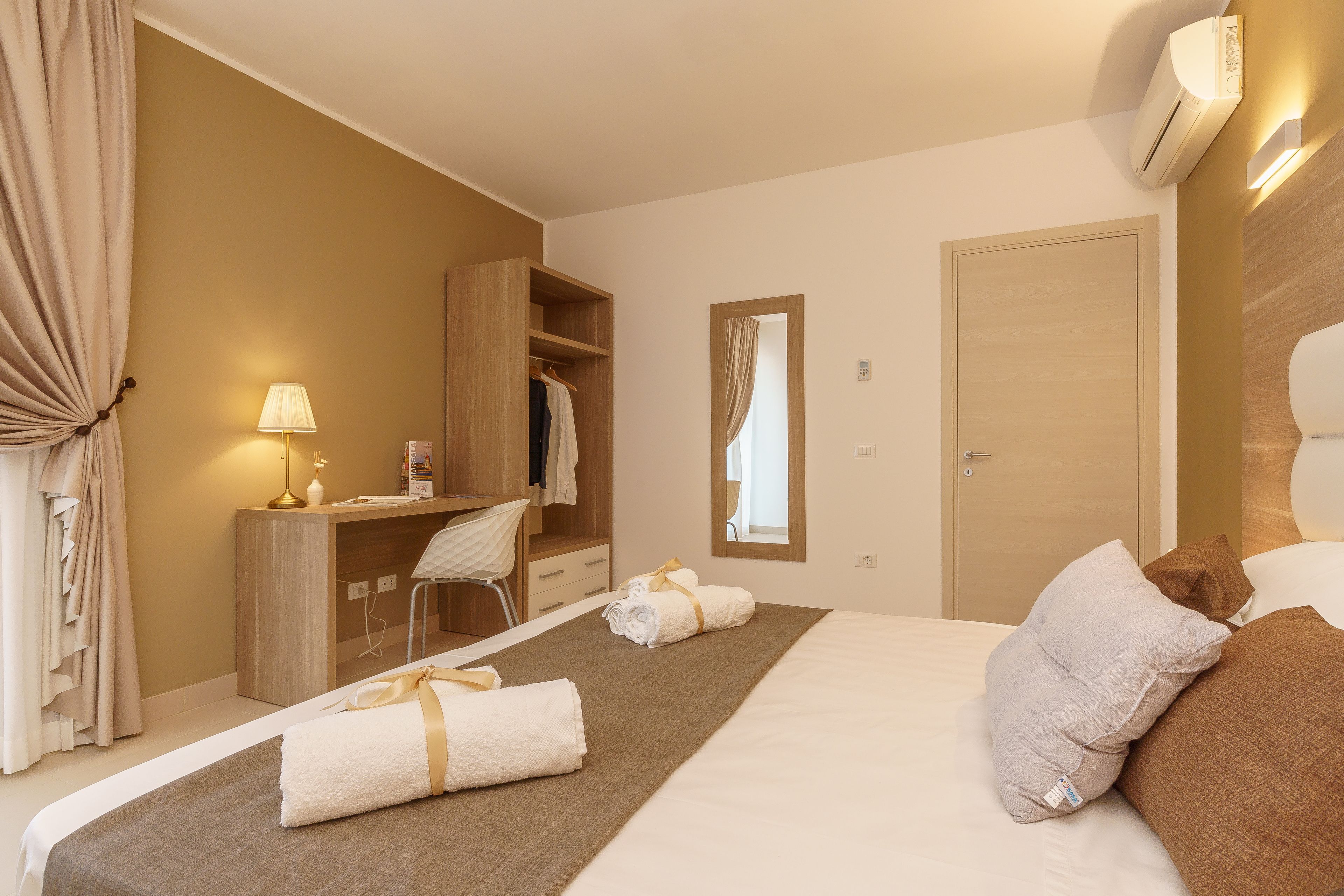 Habitación de hotel con cama, escritorio y armario.