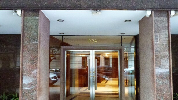 Ein Hotel mit Eingang, Glasdoor, Nummernschild und einer Treppe zum Innenbereich.