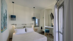 A bedroom with a bed, bedside tables, a desk, a chair, a mirror, and a window.