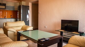 Appartement, uitzicht op stad | Woonkamer | Een 32-inch flatscreentelevisie met kabelzenders en een televisie