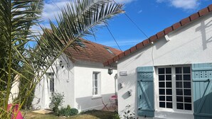 Un bâtiment blanc avec un toit recouvert de tuiles rouges, une fenêtre à volets bleus et une enseigne sur laquelle on peut lire « Salomón ».