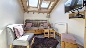 A cozy room with a sofa, a chair, a small table, and a television. - 50m from resort center, 3rd floor, tv, ski locker, 22m², Saint Martin de Belleville (Saint-Martin-de-Belleville)
