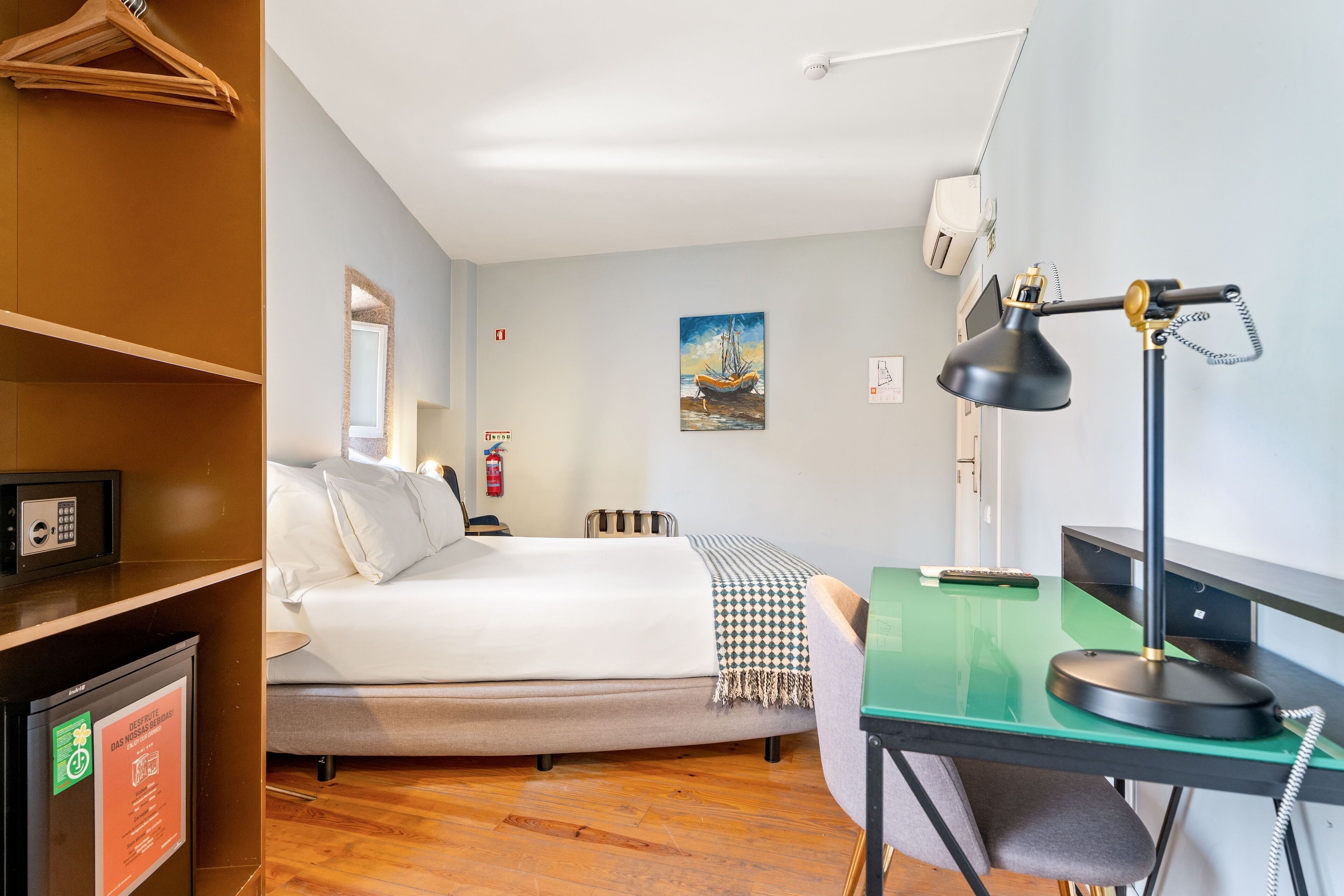 Una camera d'albergo con un letto, una scrivania, una sedia e un tavolino.