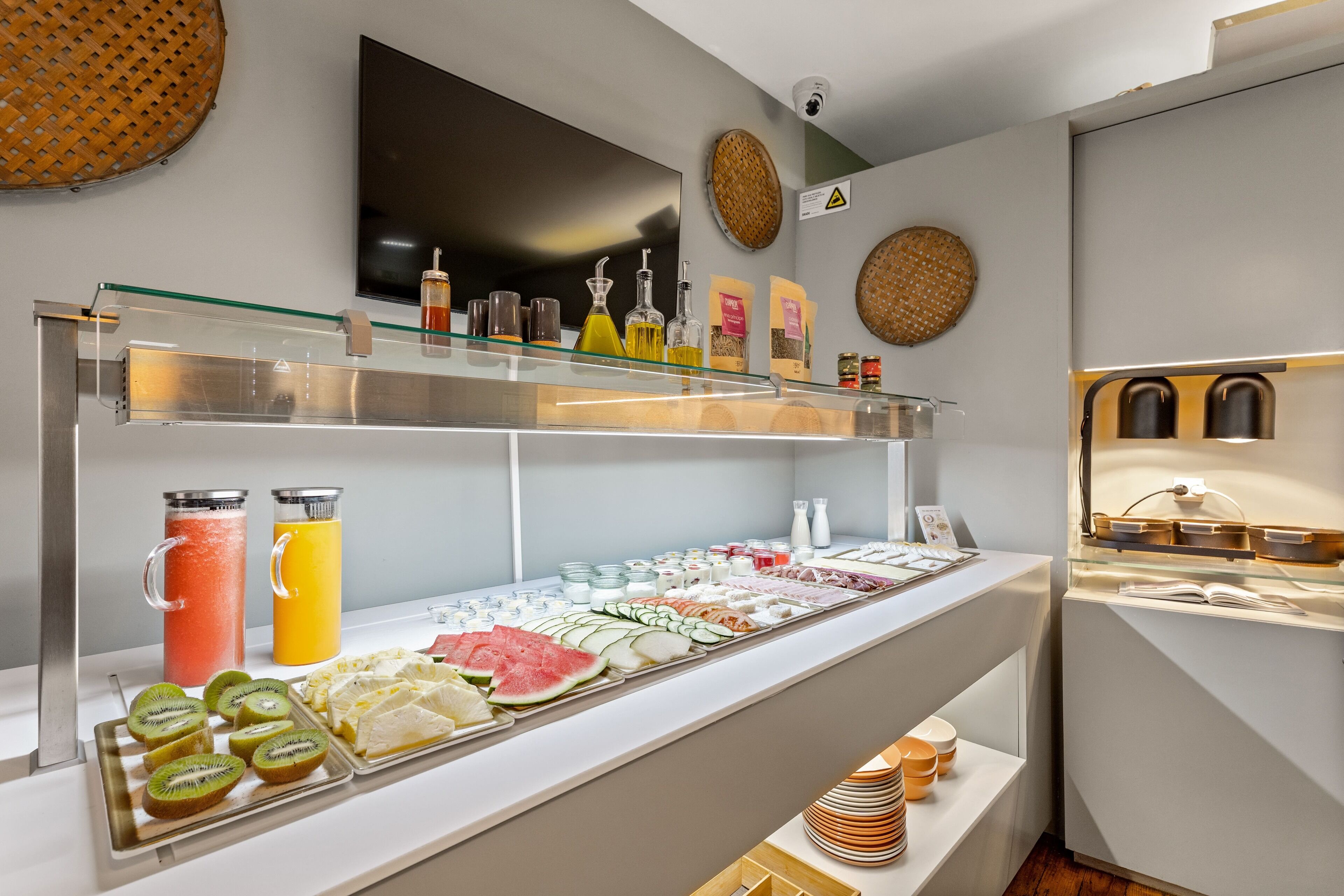 A buffet with various food items and beverages, including fruits, cheeses, and juices.