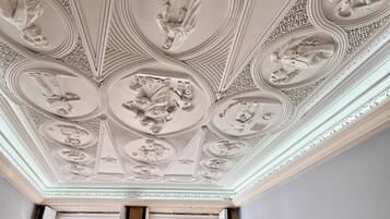 A ceiling with intricate carvings and a central circular design.