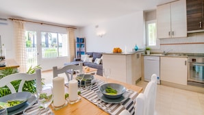 A modern apartment with a dining area, kitchen, and living space. - Apartment near the beach Avus in Alcudia (Alcúdia)