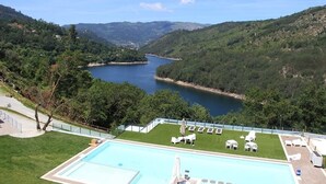 A swimming pool with a view of a lake and hills. - Dobau Village (Vieira do Minho)