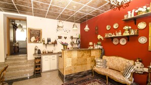 Un intérieur chaleureux avec un mur rouge, un canapé vintage, un banc en bois et un tapis à motifs.